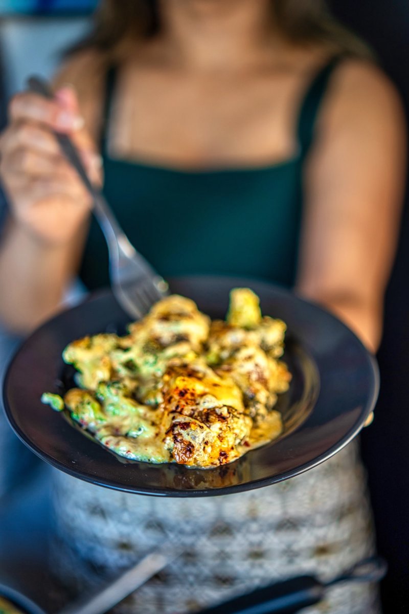 Serving of cheesy broccoli casserole with tender broccoli florets coated in creamy garlic cheese sauce