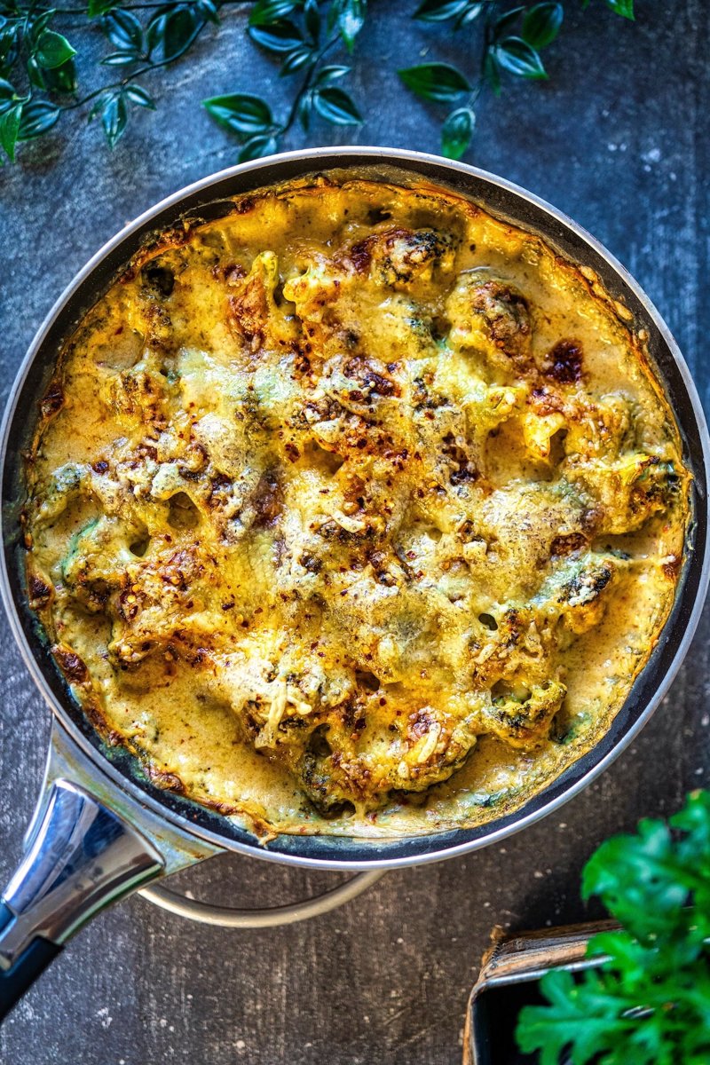 Overhead view of homemade cheesy broccoli casserole with creamy garlic cheese sauce and golden Emmental cheese