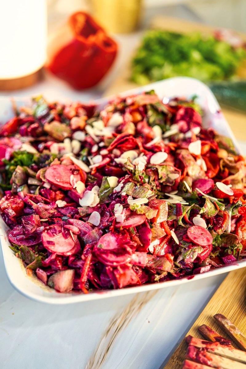 Close-up of fresh chickpeas and beet salad garnished with sliced almonds.