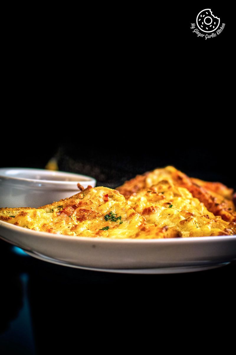 chilli cheese toast snack served in a white plate