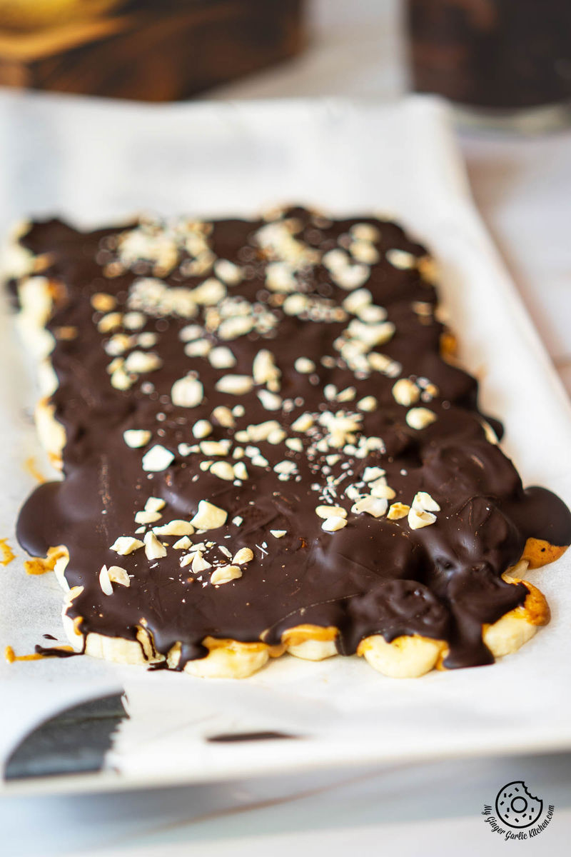 tray of viral chocolate banana bark pieces on a white sheet of waxed paper next