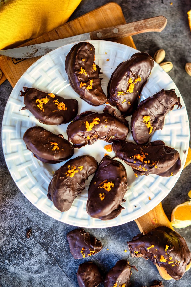 chocolate covered oranges on a plate with a knife