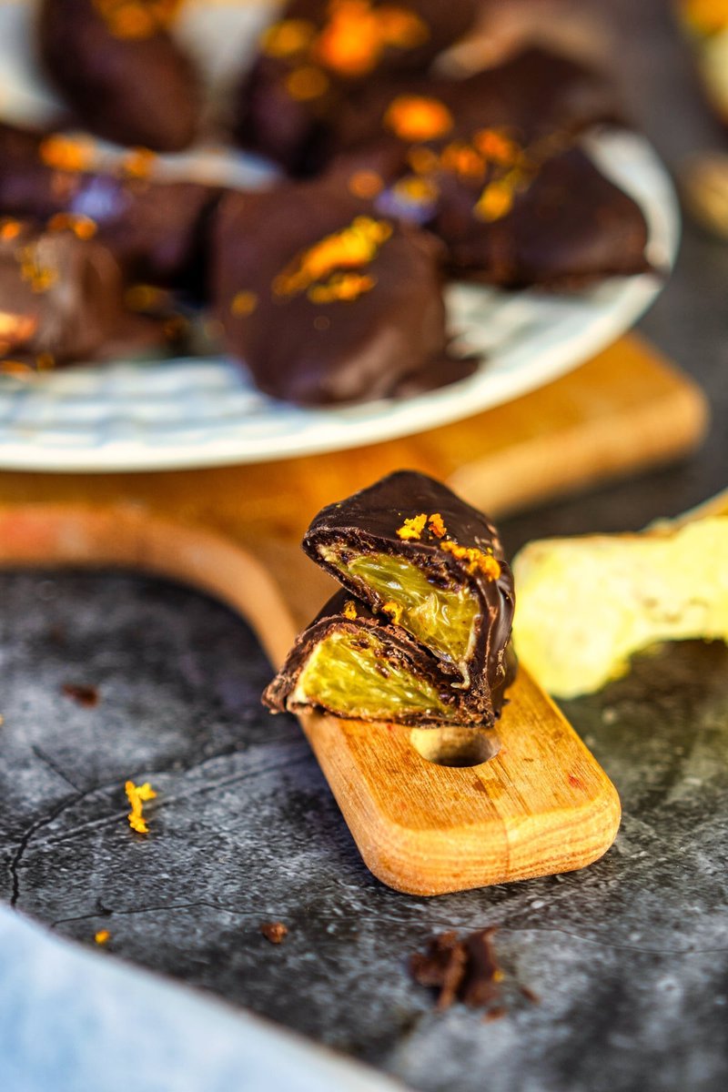 a chocolate covered orange cut in half on a wooden board