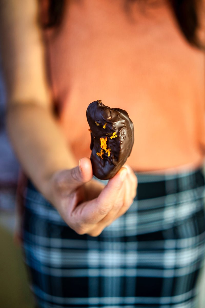 someone is holding a chocolate covered ornage with zest on top in their hand