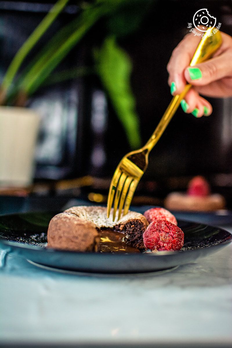a female hand with a golden knife with chocolate lava cake