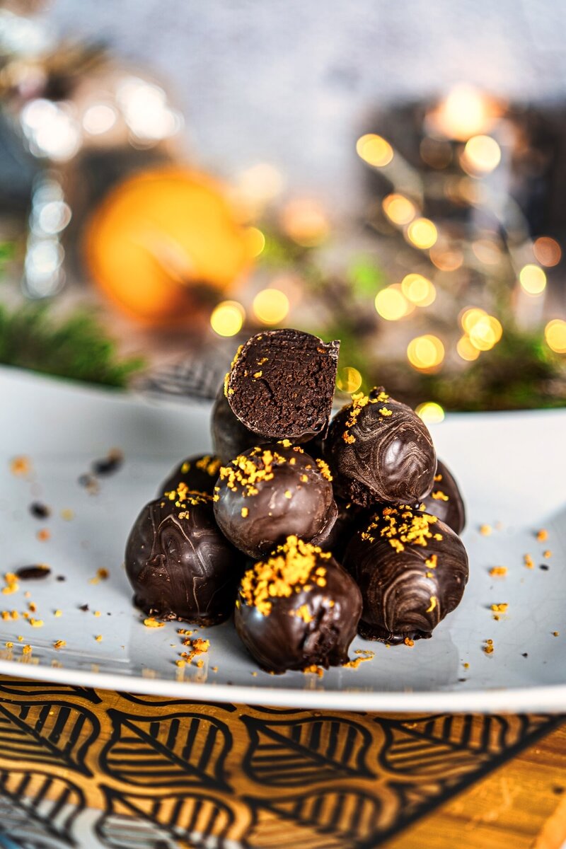Close-up of chocolate orange truffles stacked together showing glossy dark chocolate coating and orange zest