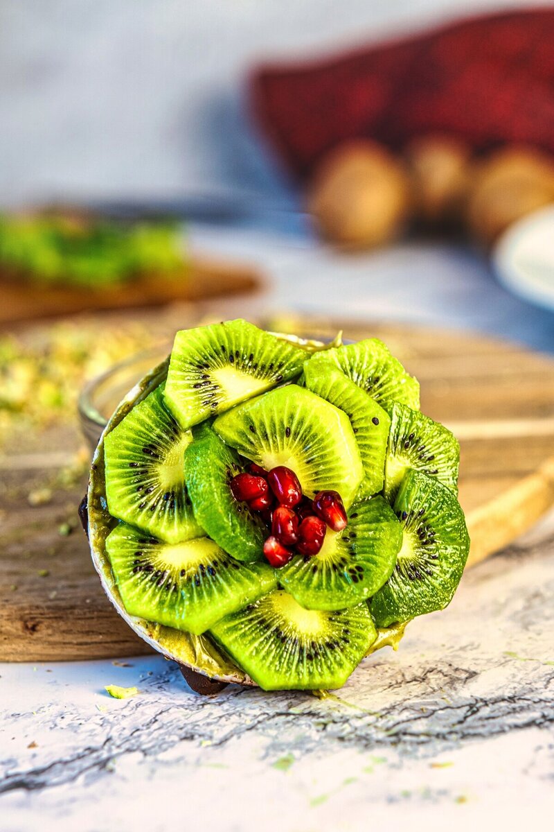 Overhead view of Chocolate Pistachio Kiwi Rice Cakes on a white plate, no bake vegan gluten free dessert with dark chocolate and fresh fruit