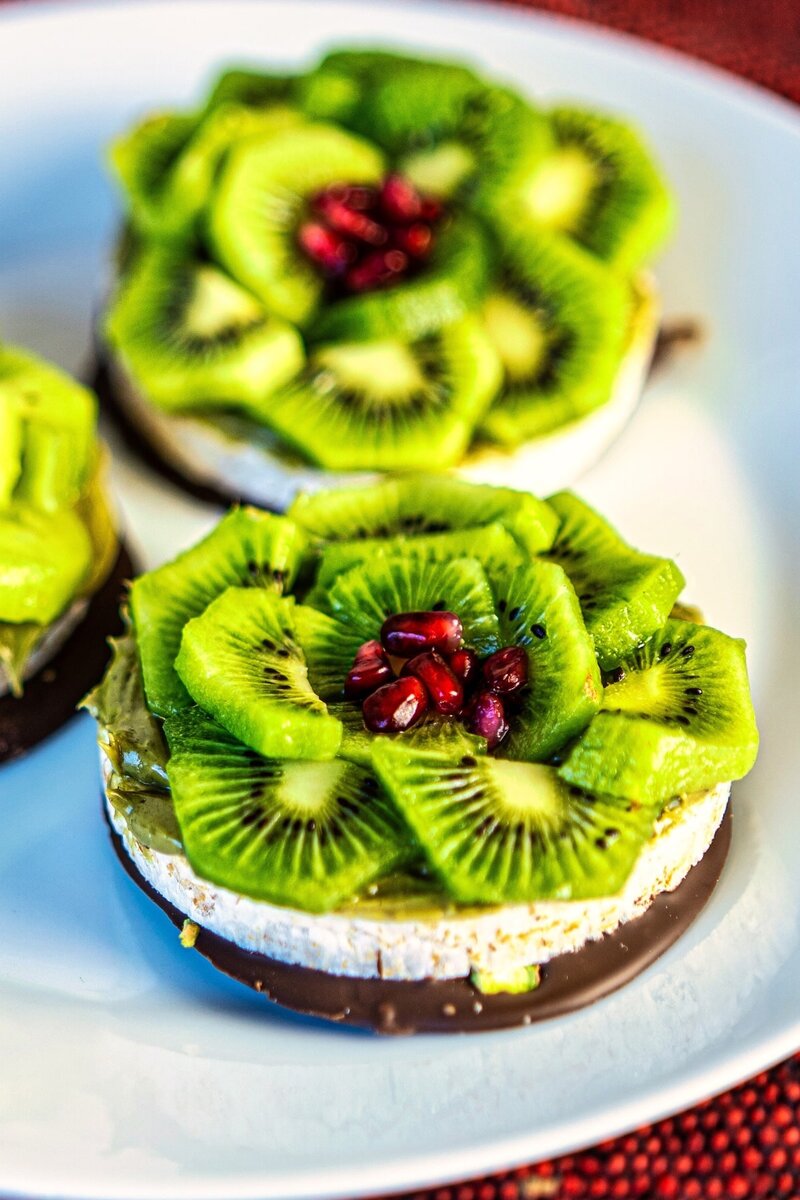 Top view of healthy chocolate pistachio rice cakes with kiwi and pomegranate, quick 20 minute gluten free dessert idea