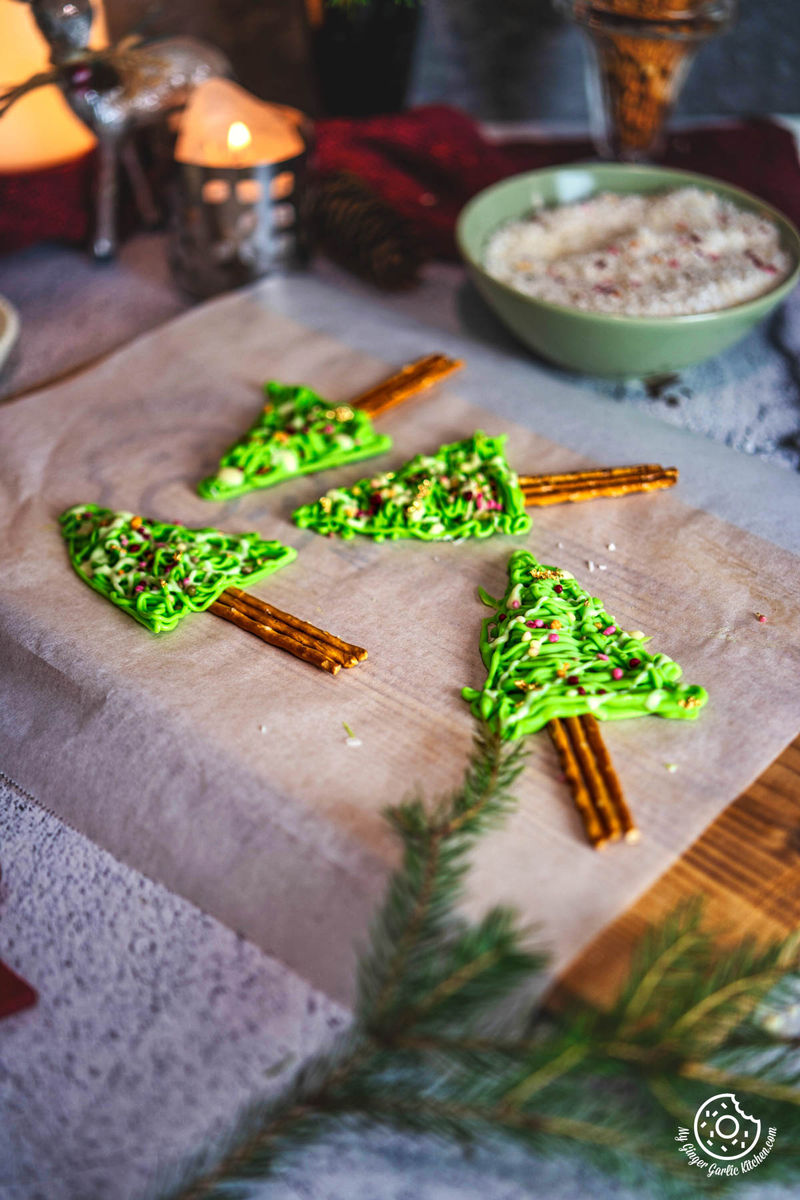 A picture of four pretzel Christmas trees made with green chocolate.