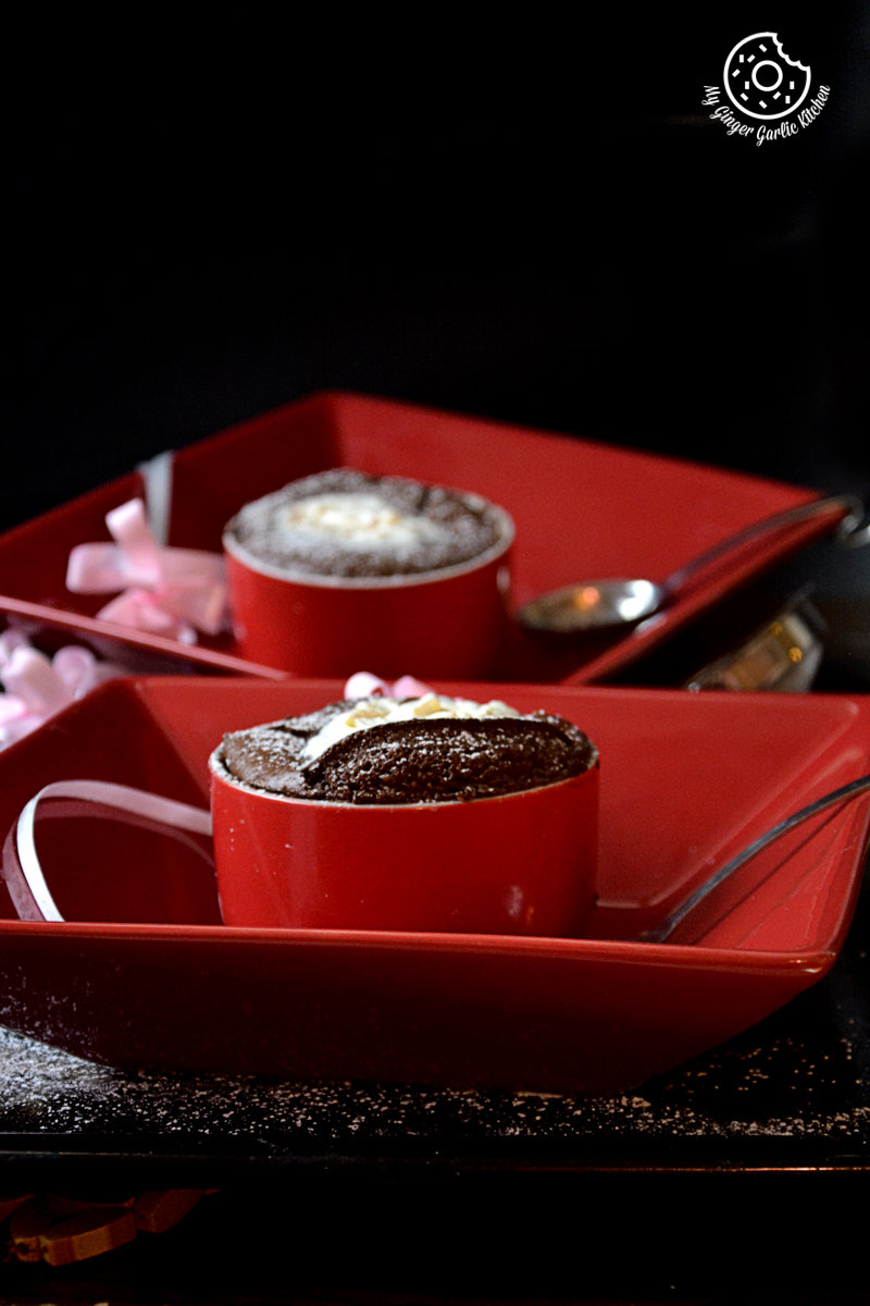 two red bowls with chocolate souffles on them