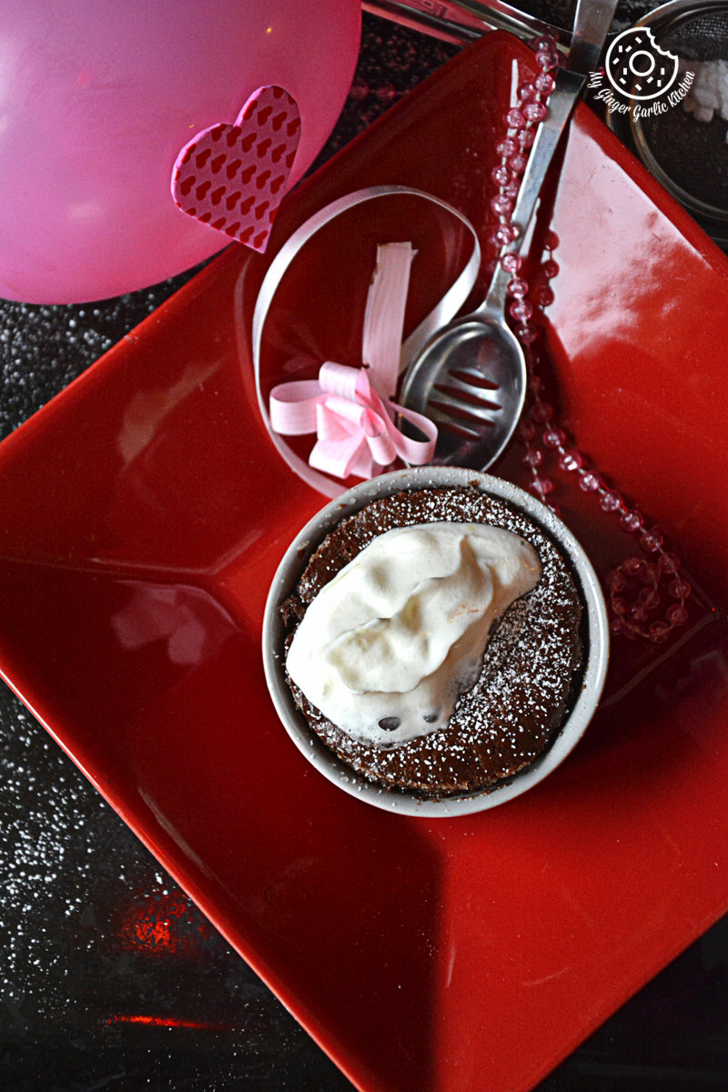 a red plate with a chocolate souffle and a pink balloon