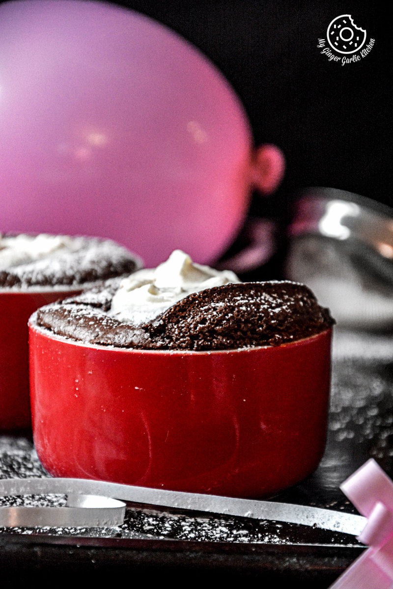 two red bowls with chocolate souffle in them on a table