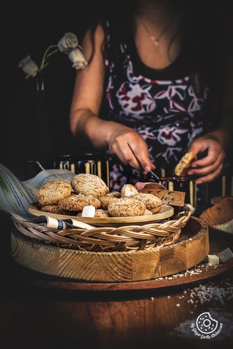 coconut cookies in a wooden plate and a female in the background