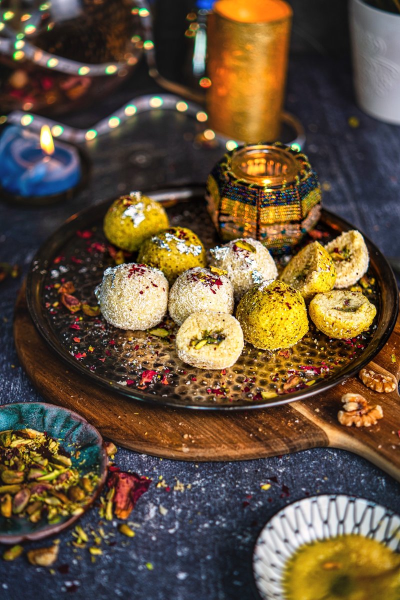 Coconut ladoo truffles with white chocolate pistachio filling, shown whole and cut open to reveal the creamy centre, perfect for Diwali sweets.