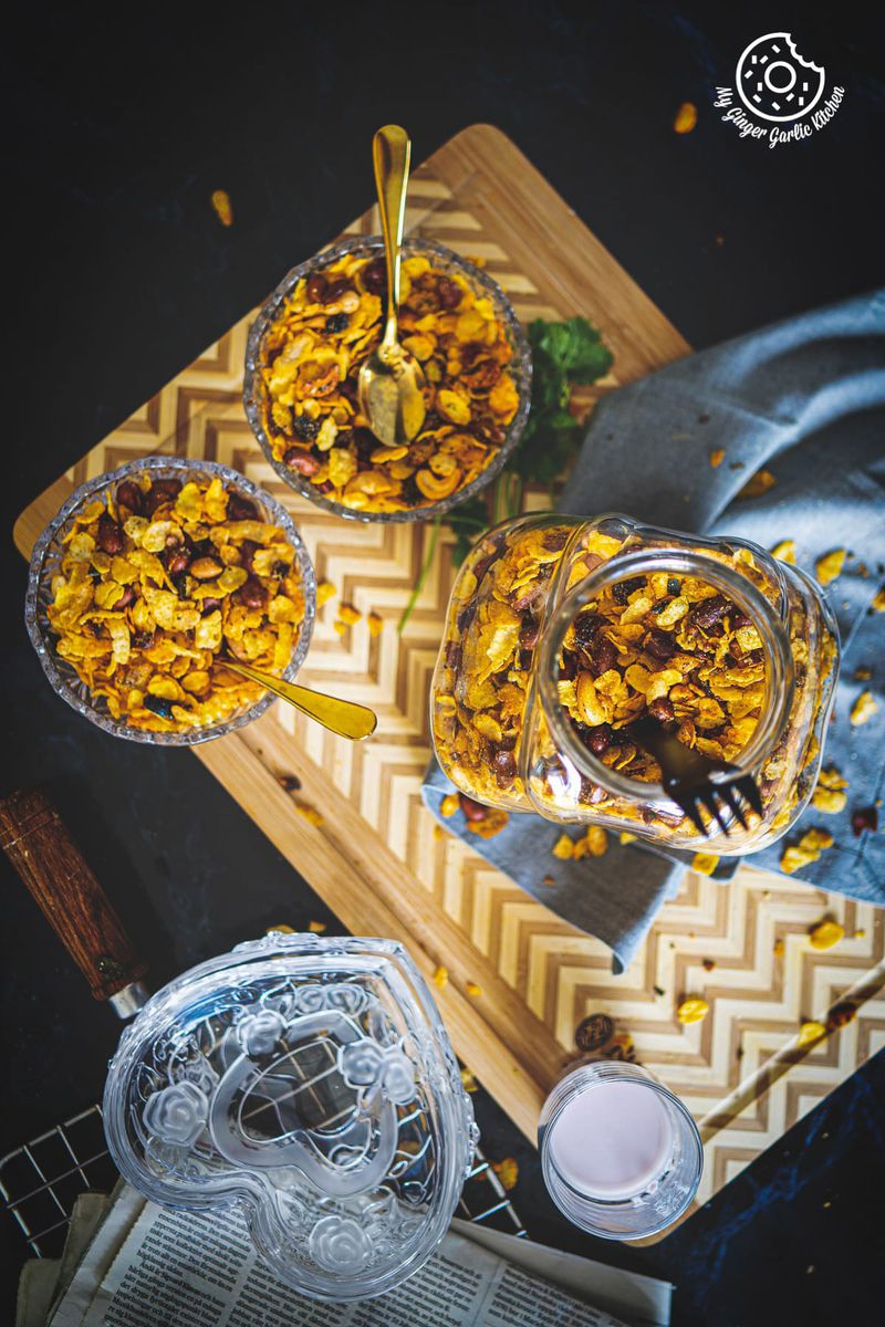 overhead shot of roasted cornflakes chivda in a jar and transparent bowls