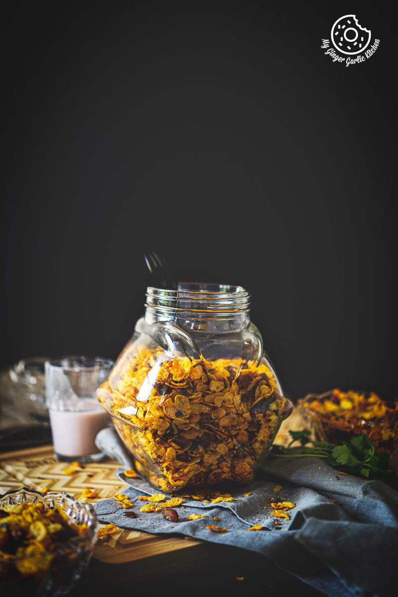 a jar of roasted cornflakes chivda namkeen kept on a wooden board