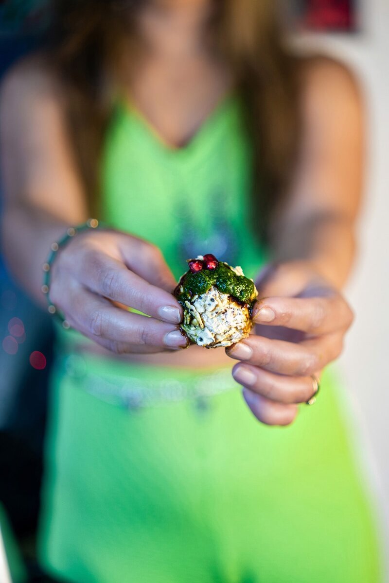 Close-up of a Cream Cheese Corn Chaat Ball topped with mint chutney, tamarind chutney, and pomegranate arils. A creamy, crunchy, and colorful no-cook Diwali appetizer.