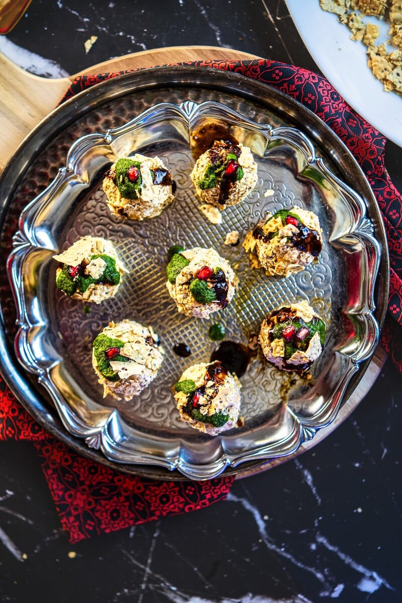 Overhead shot of Cream Cheese Corn Chaat Balls garnished with green chutney, tamarind chutney, and pomegranate. A vibrant no-cook party appetizer perfect for Diwali.