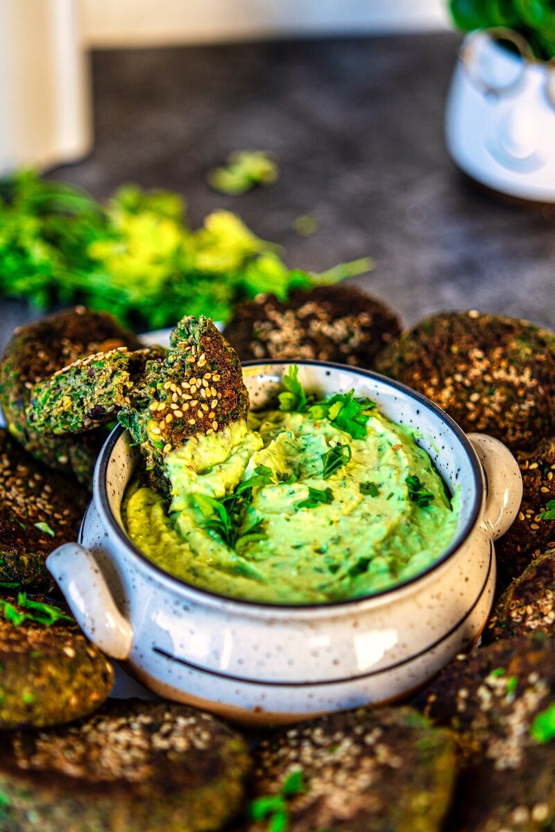 Crispy black bean veggie patties dipped in creamy avocado dip high protein vegetarian patties