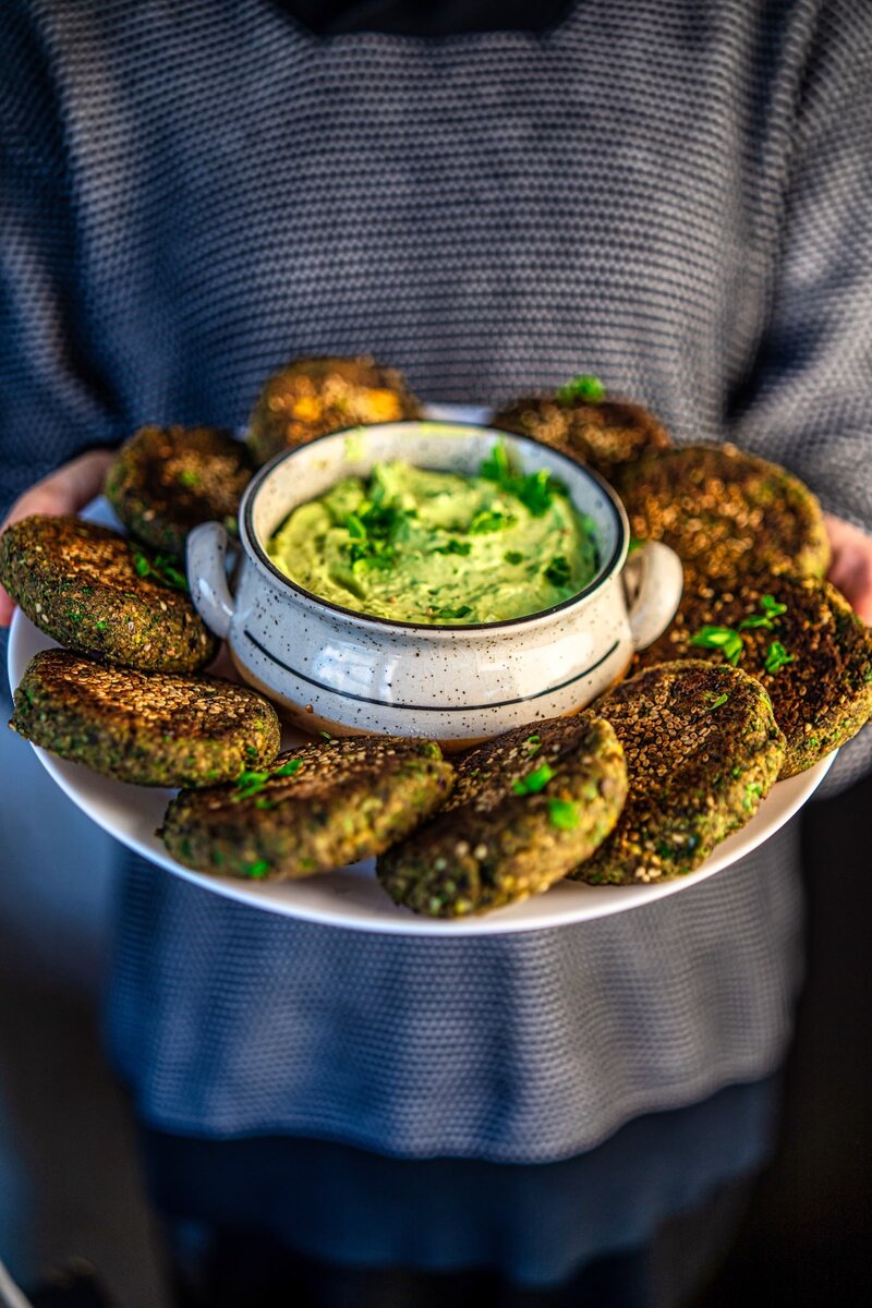 Homemade black bean veggie patties with sesame crust served with creamy avocado dip