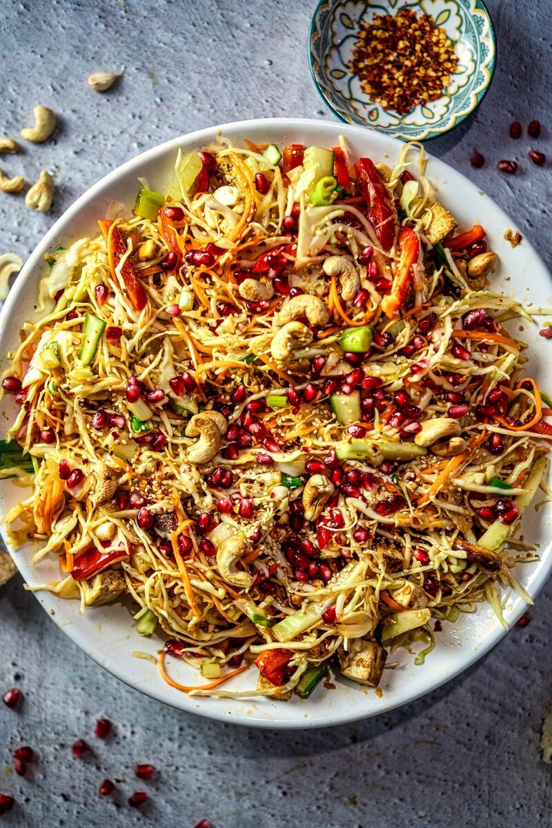 Crunchy sesame lime cabbage salad with roasted tofu, cashews, carrots, cucumber, and sesame seeds