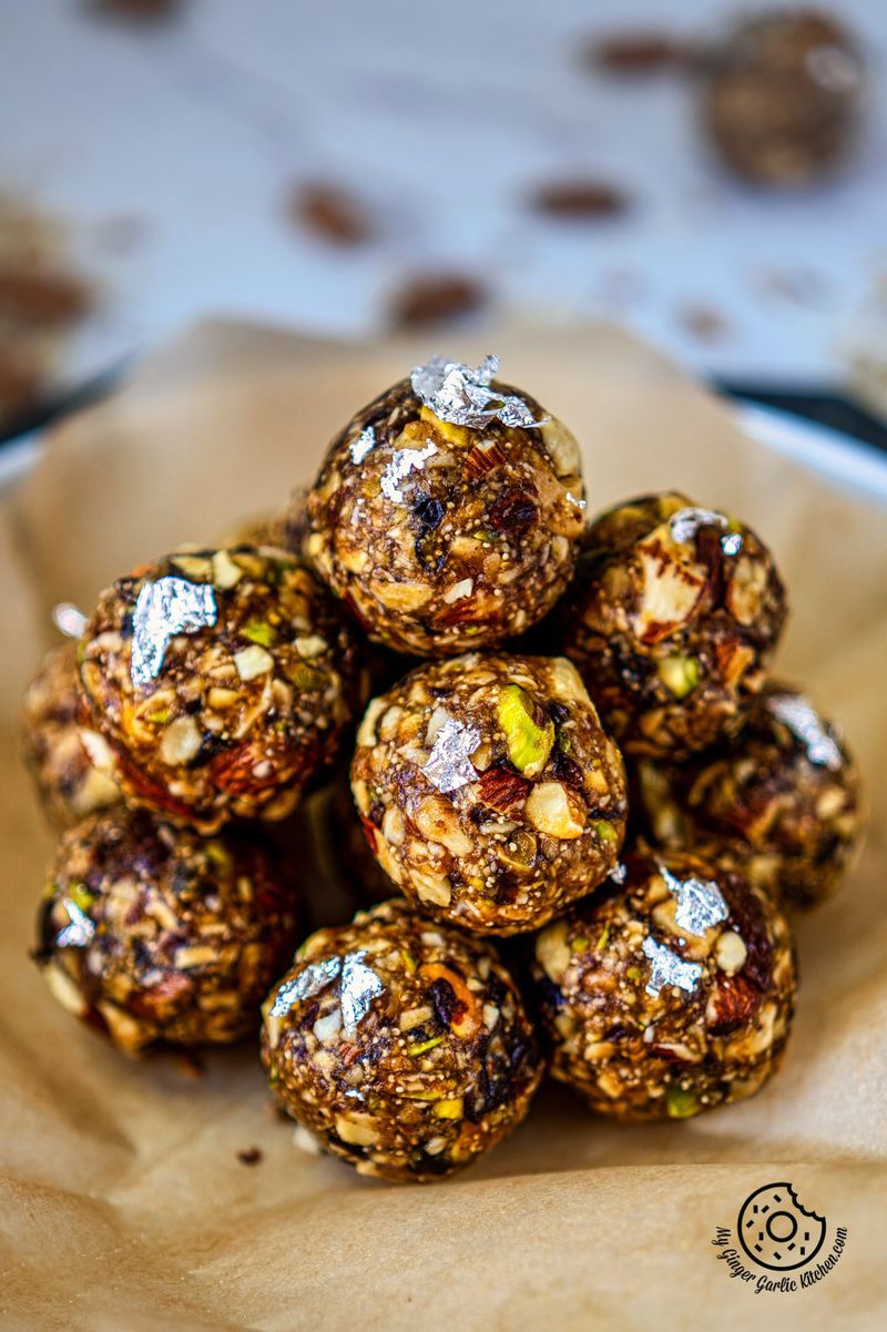 stack of dry fruits laddu on a parchment paper lined white ceramic plate