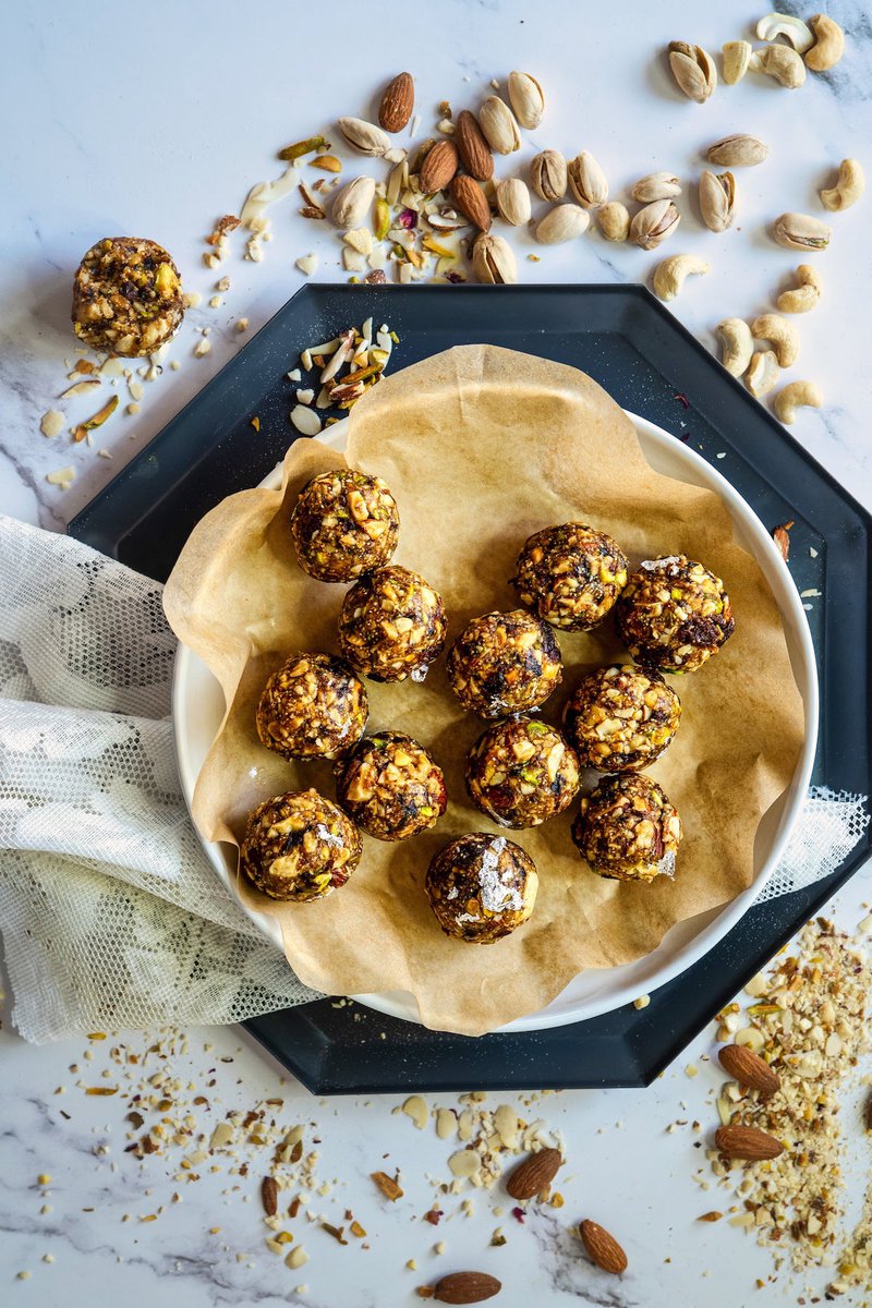 dry fruits laddus on a plate on a table with more dry fruits