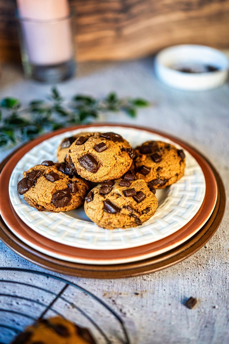 Eggless brown butter chocolate chip cookies stacked on a plate with melty dark chocolate chunks, crispy edges, and soft chewy centers, bakery-style homemade cookies without eggs
