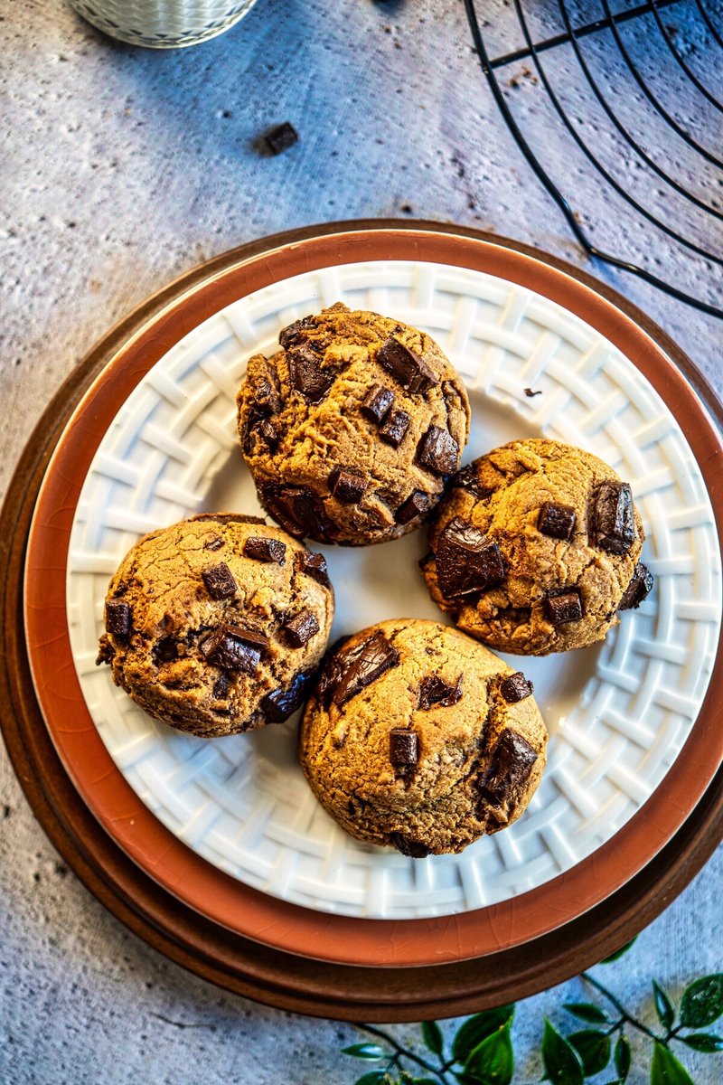 Top view of thick eggless brown butter chocolate chip cookies with gooey dark chocolate chunks on a plate, soft chewy bakery-style homemade cookies