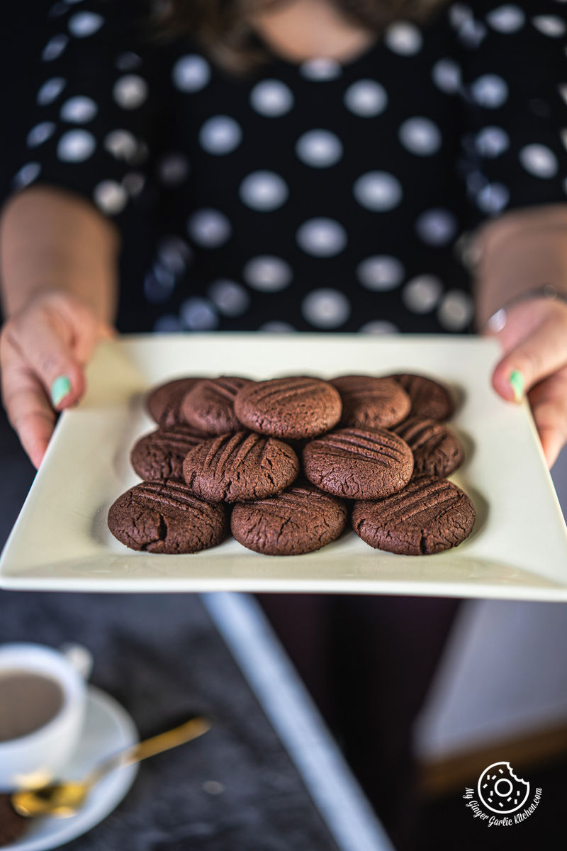 a female holding a square plate filled with nutella cookies