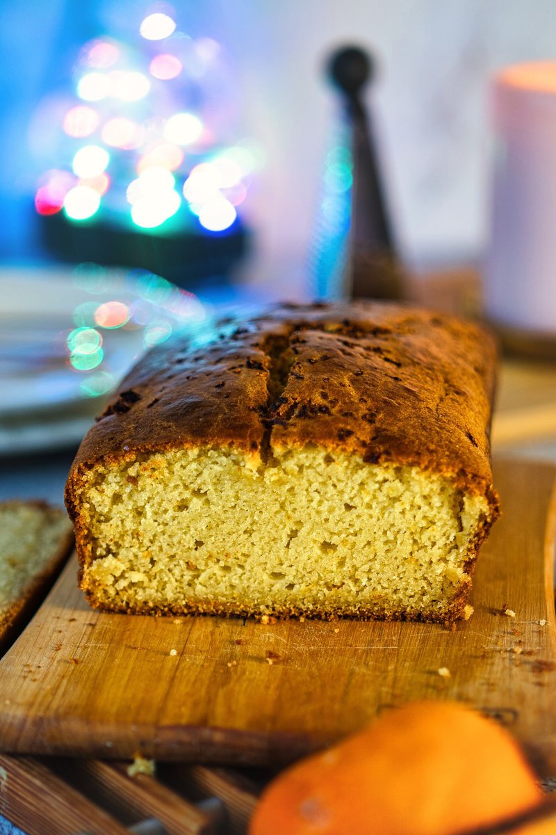 Close-up of an eggless orange loaf cake on a wooden board.