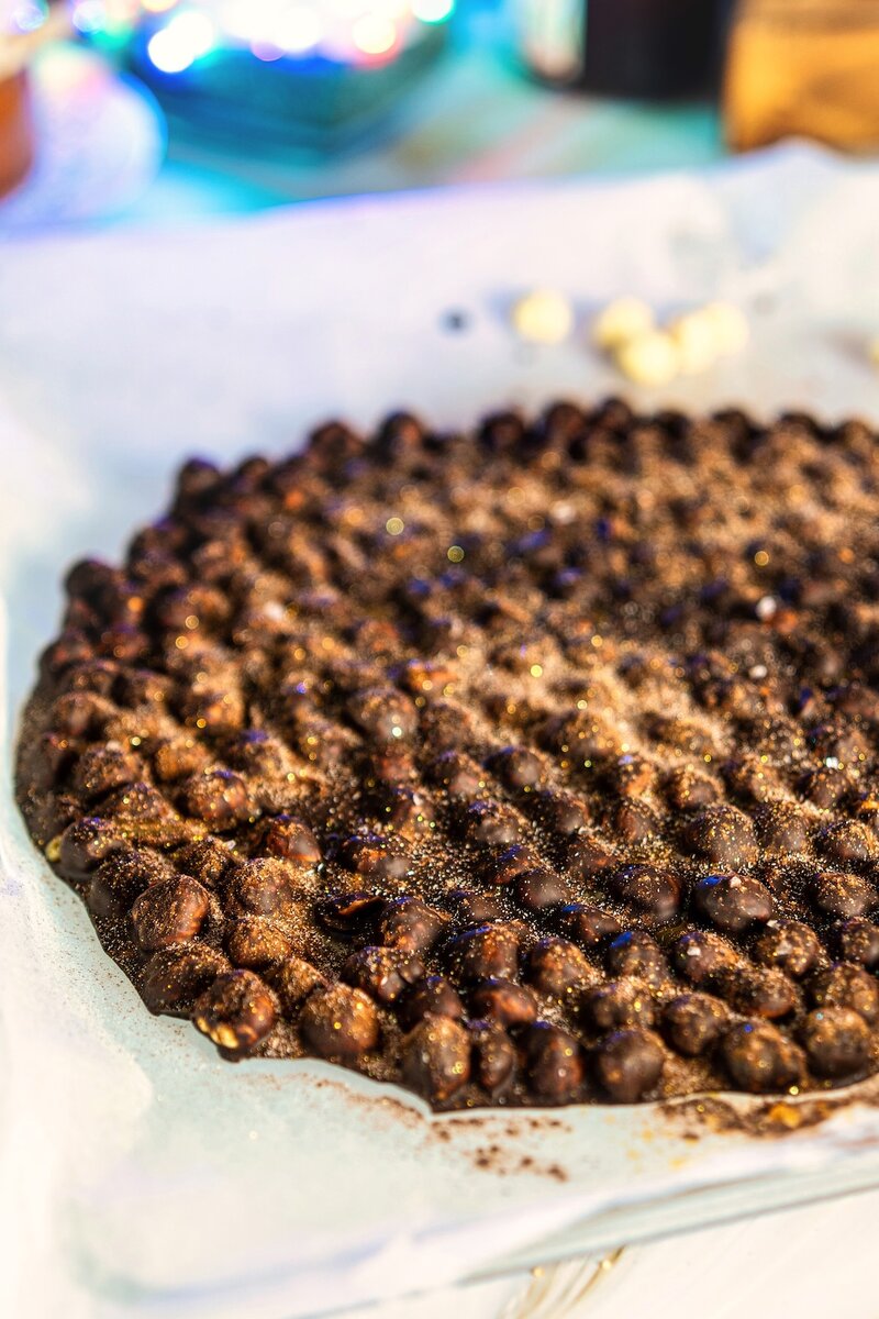 Large round espresso hazelnut dark chocolate bark on parchment paper, gluten-free no-bake chocolate bark recipe
