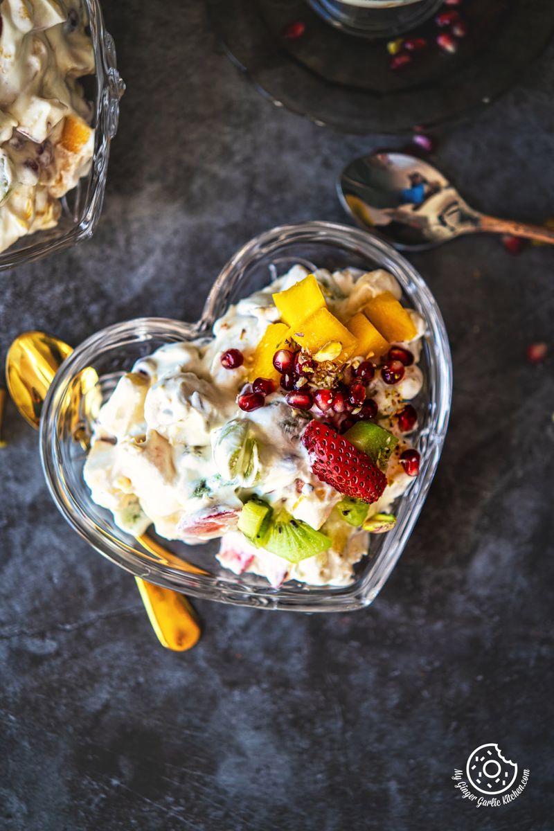 overhead view of fruit cream served in a transparent heart shaped bowl