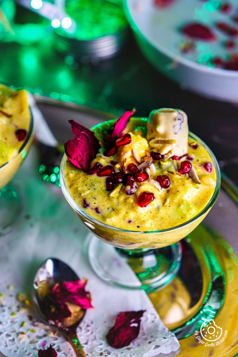 closeup shot of fruit rabri decorated with pomegranate in transparent dessert glass