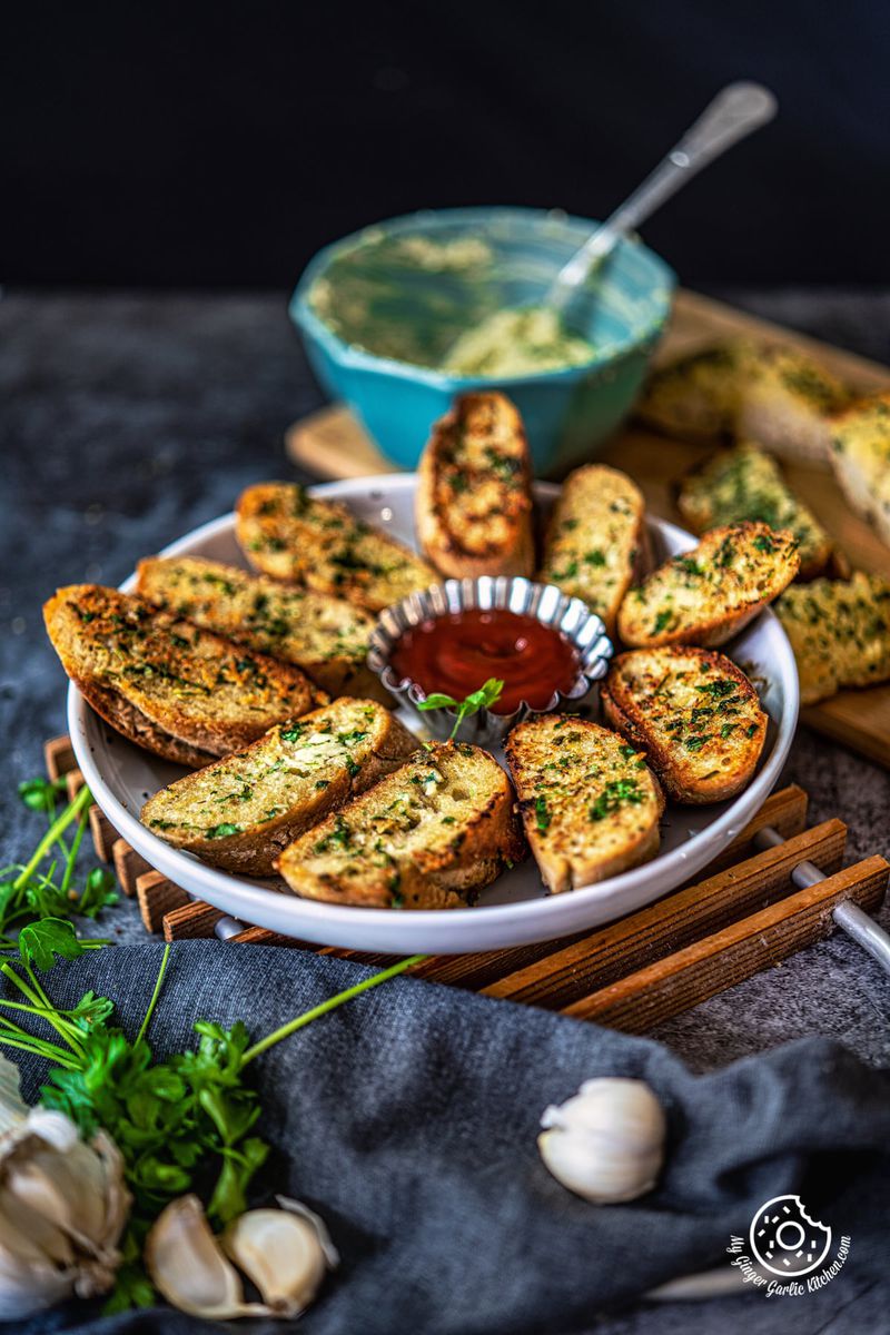 garlic bread in white plate along with a ketchup bowl
