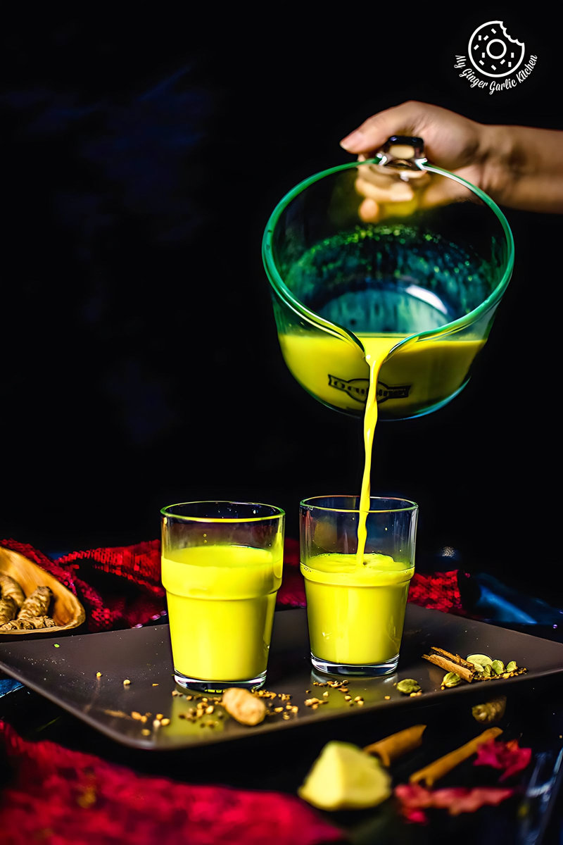 a pouring shot of golden milk (haldi doodh)