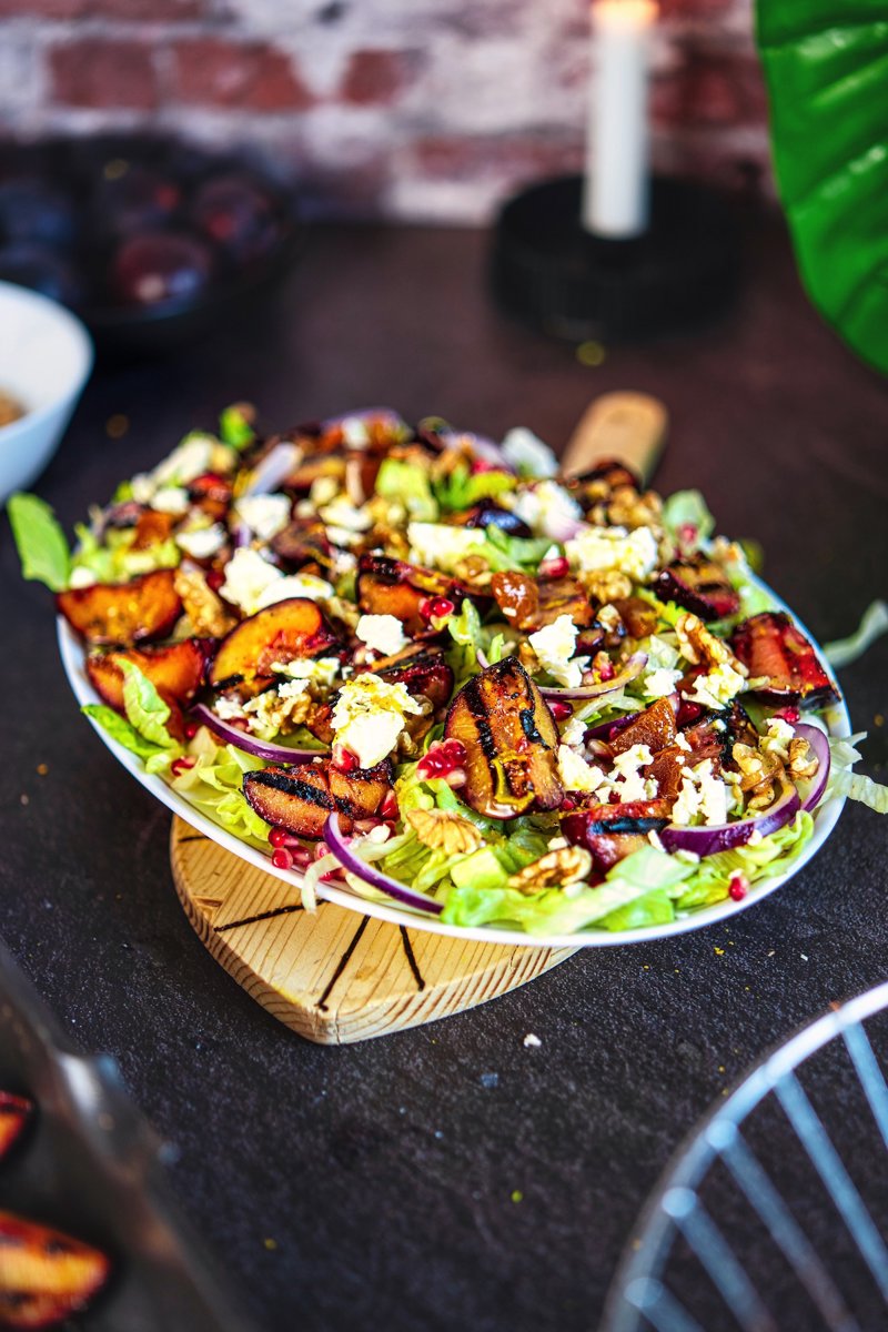 Grilled plum salad with caramelized plums, feta, walnuts, pomegranate, and orange vinaigrette