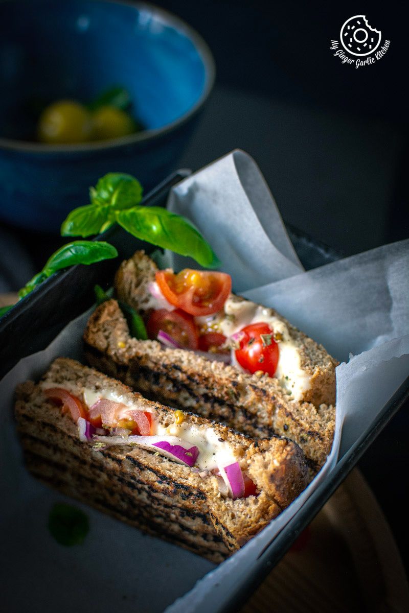 grilled tomato mozzarella sandwiches with tomatoes and cheese on it in a basket