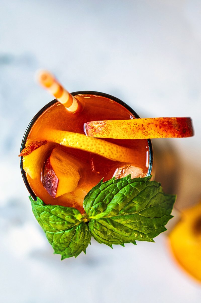 Refreshing peach iced tea with fresh peaches and mint served over ice