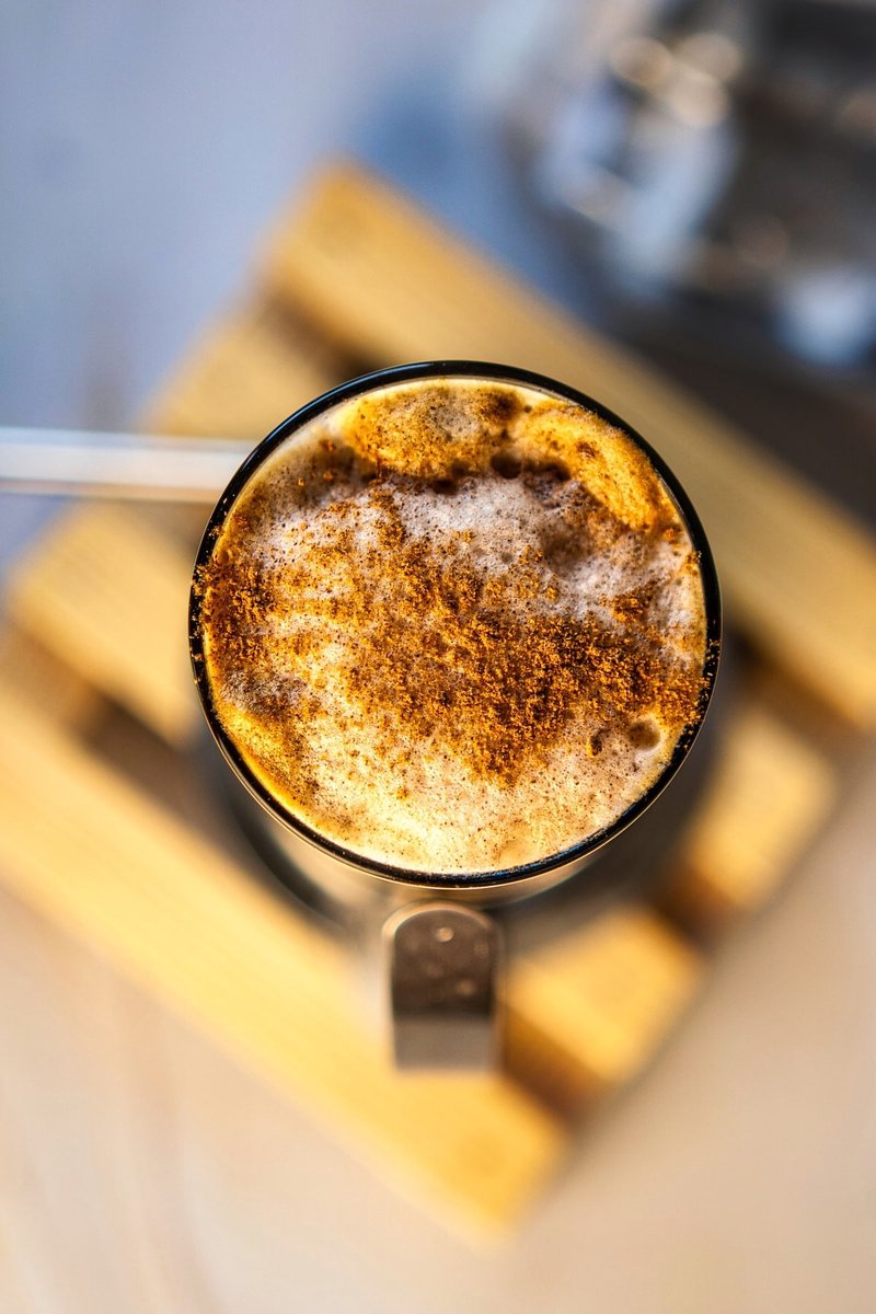 Close-up of Honey Cinnamon Iced Coffee with fluffy whipped coffee, cinnamon milk, ice, and cinnamon sprinkled on top
