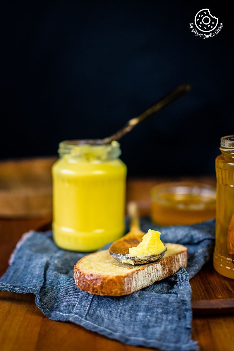 ghee in a glass jar and a wooden spoon