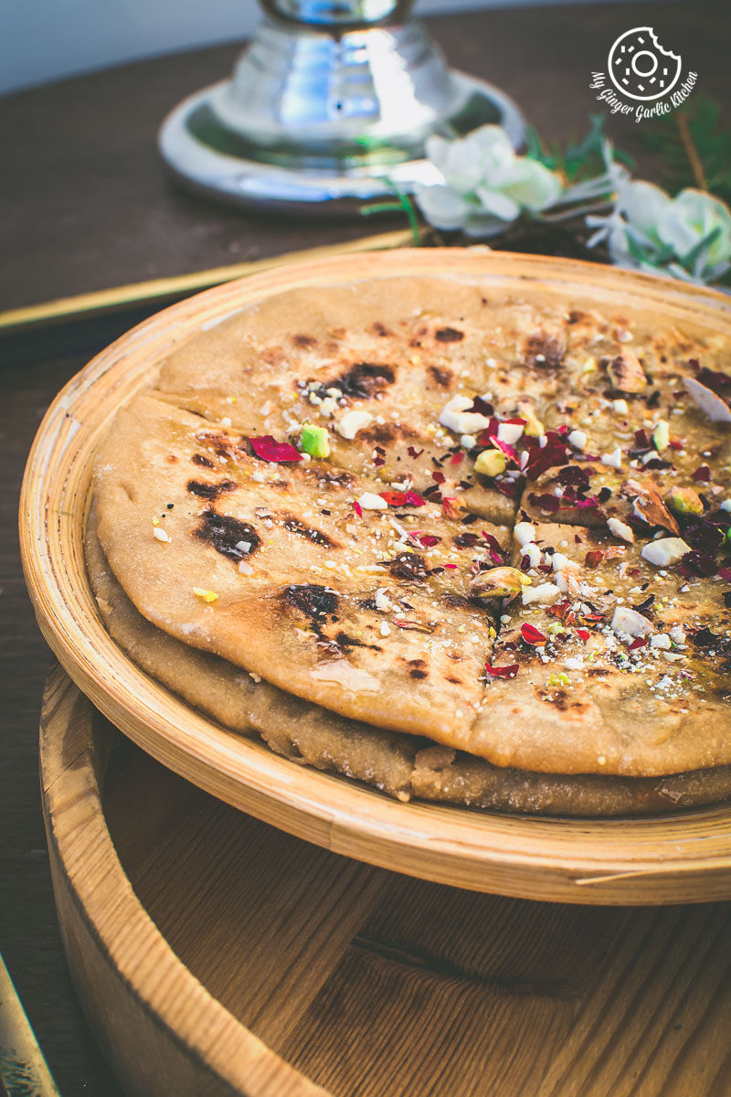 two gulkand dessert parathas on a wooden plate on a table
