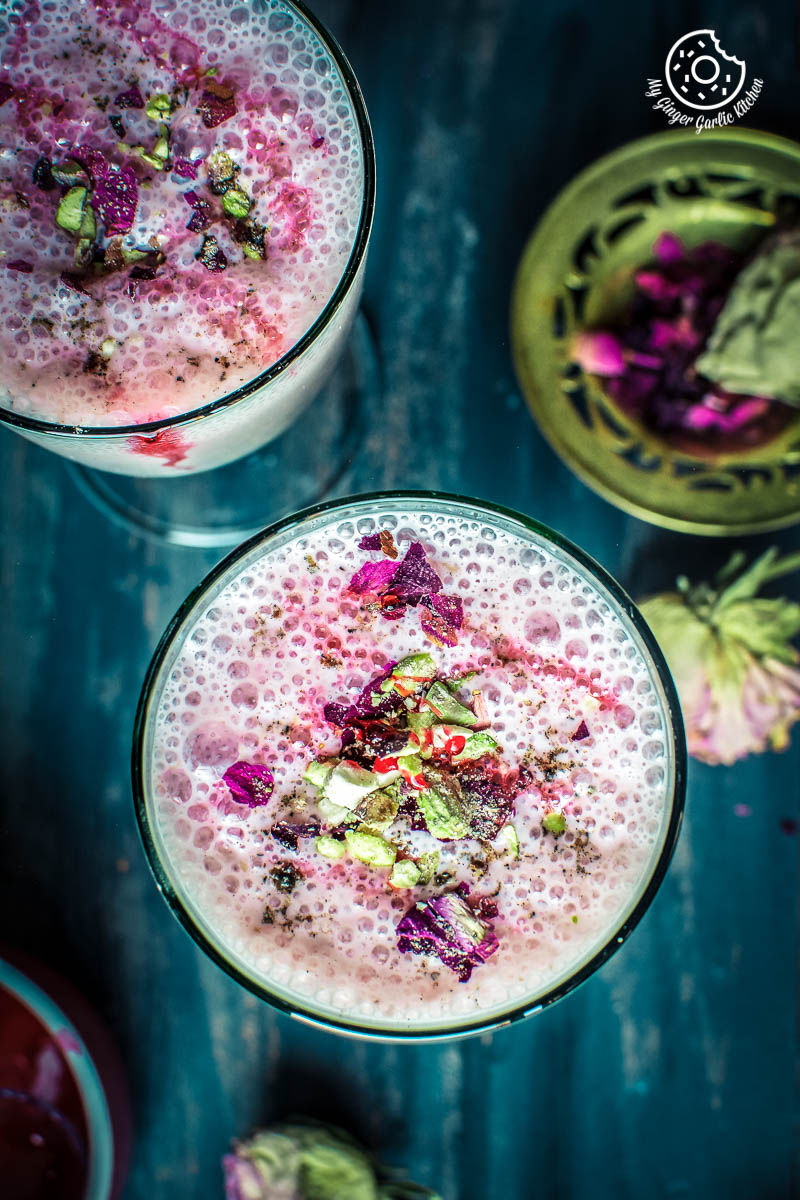 two glasses of gulkand lassi  with flowers on the table