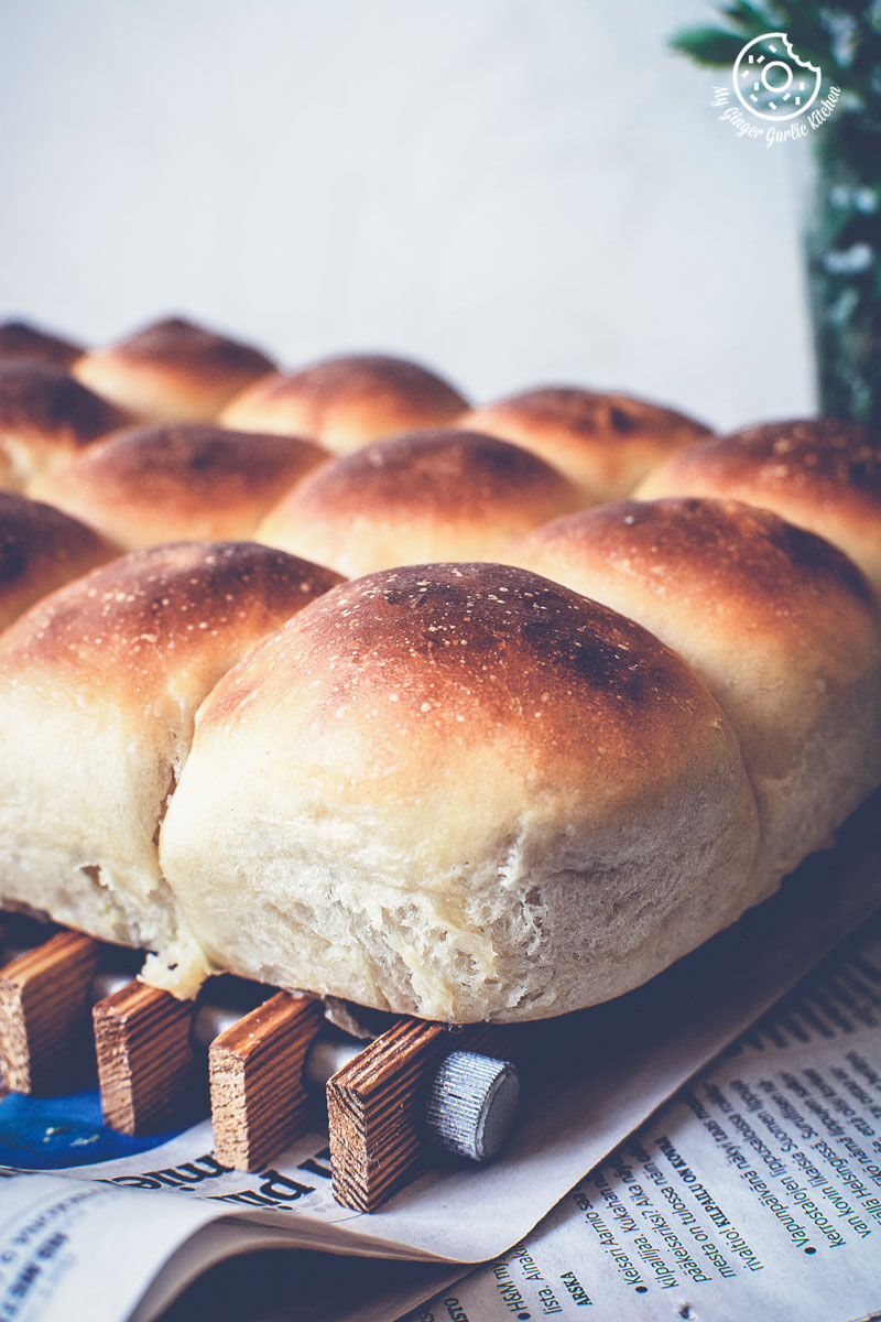 soft, fluffy, spongy ladi pav or dinner rolls on a wooden plate on a table
