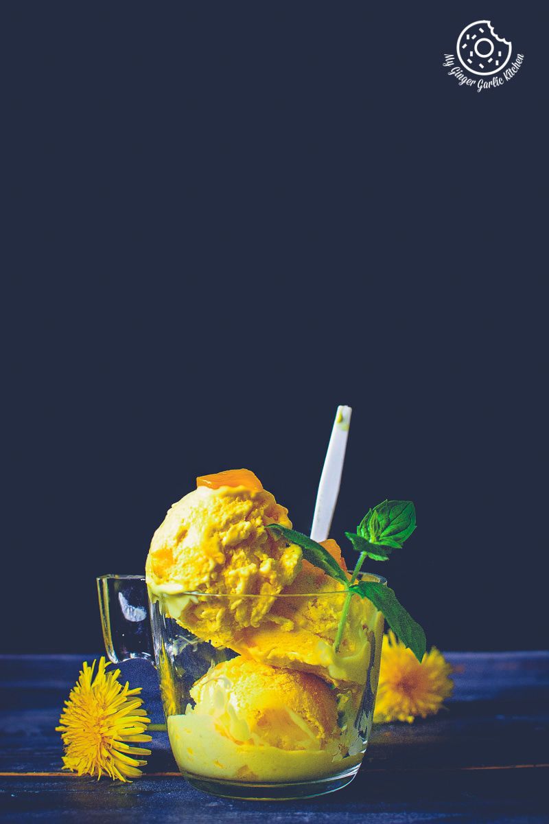 a glass of ice cream with a spoon and a flower