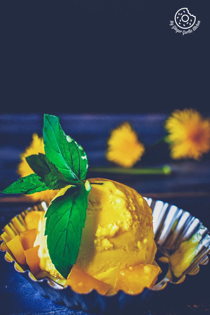 a small bowl of mango ice cream with a leaf on top