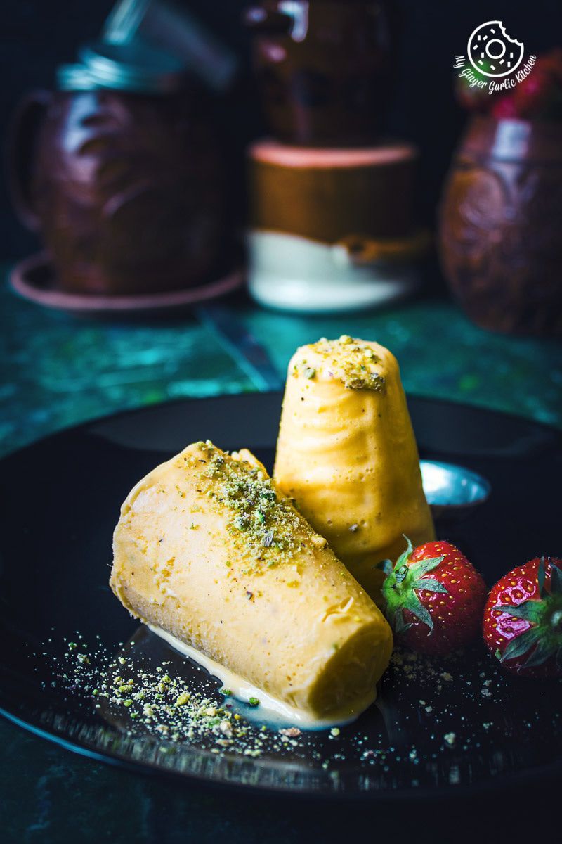 a plate with a mango kulfi dessert on it and strawberries