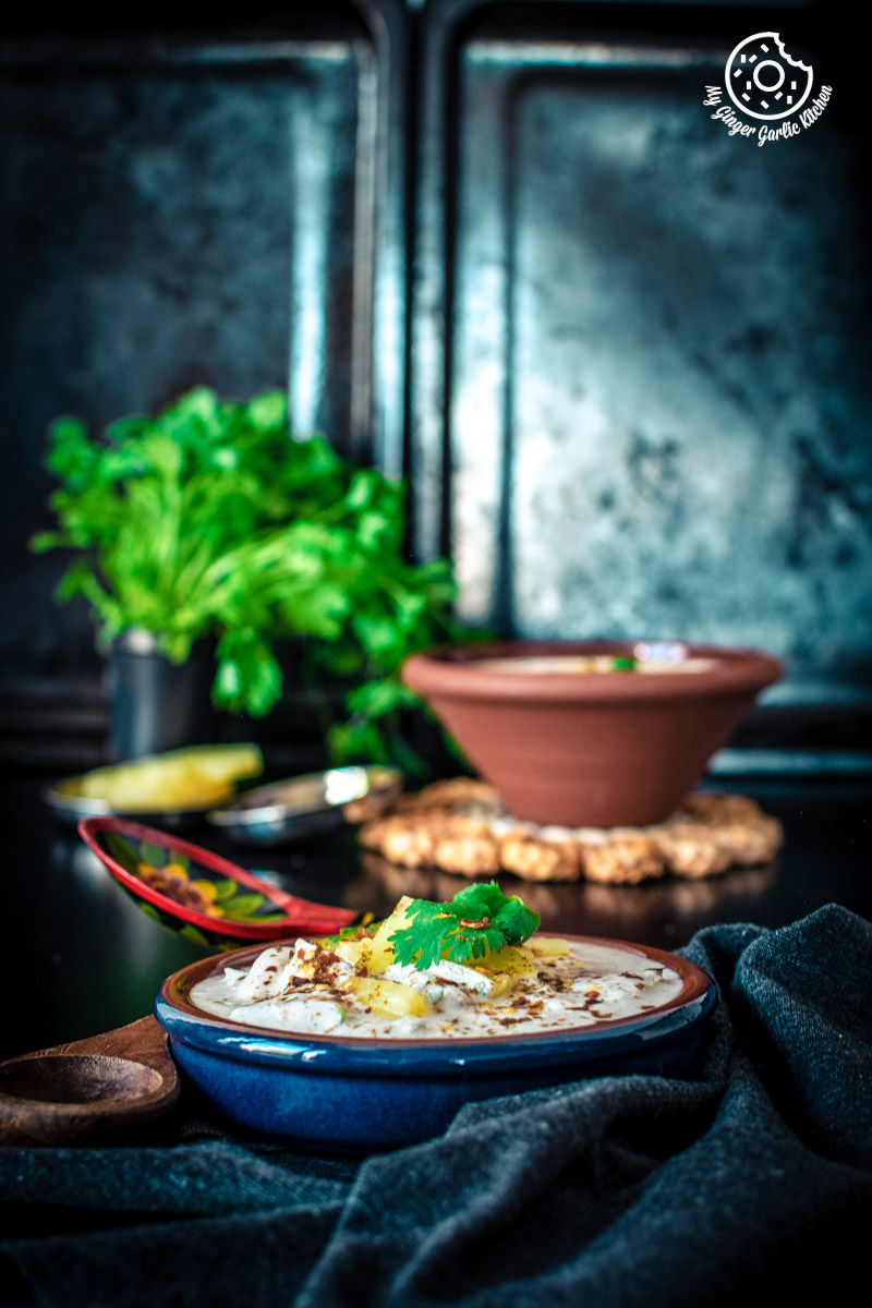a bowl of pineapple raita topped with cilantro on a table