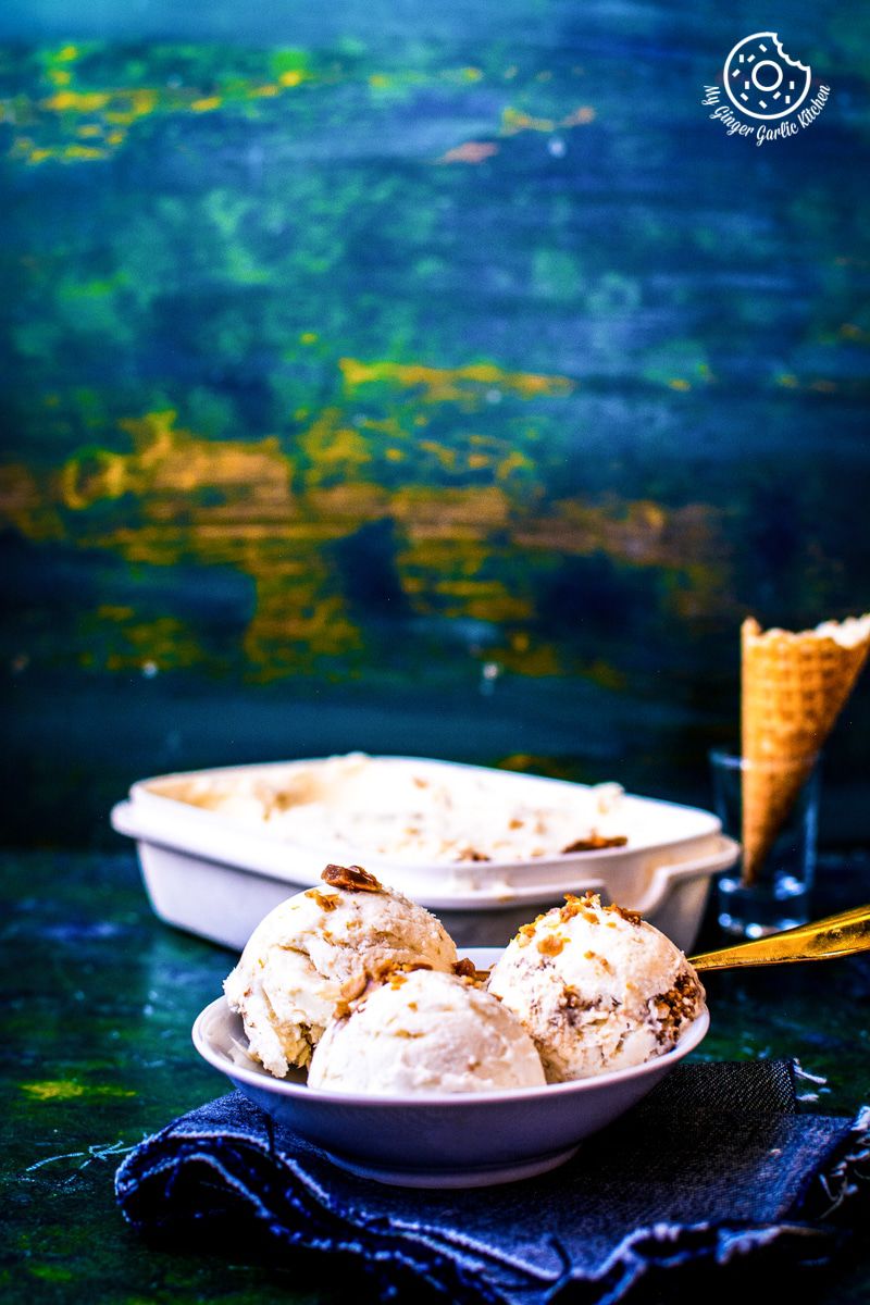 a bowl of three indian butterscotch ice cream scoops on a table