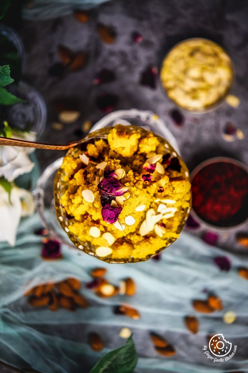 overhead shot of instant badam halwa served in a transparent bowl